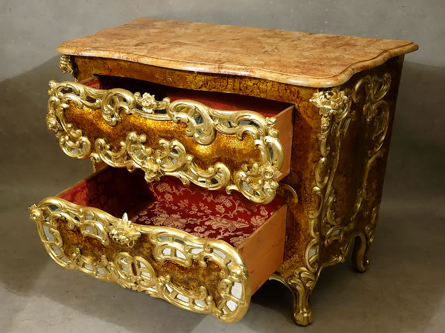 Commode rococo aux tiroirs garnis d’un damas de soie rouge et or